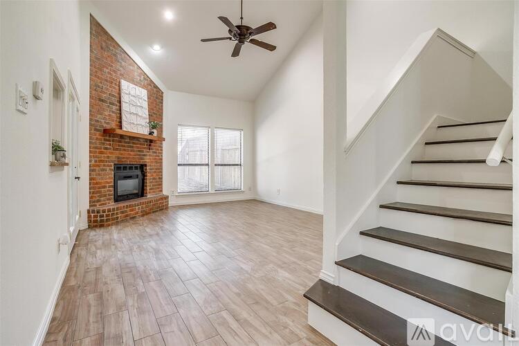 A living room with a fireplace and a staircase.