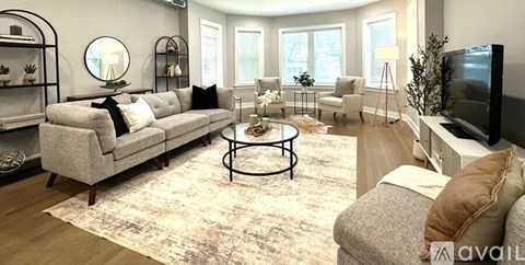 A living room with a grey sofa, a coffee table, and a television.