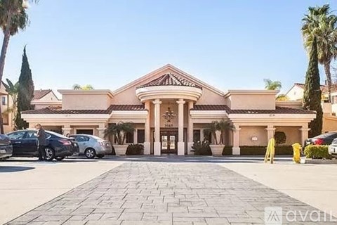 A large building with a tiled roof and a driveway in front.