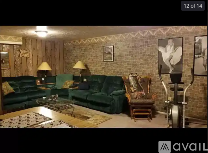 A living room with a green couch and a lamp.