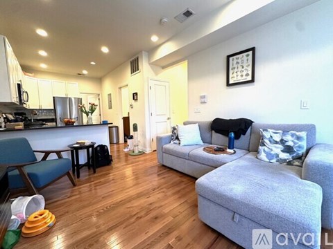 A living room with a grey couch and a blue chair.