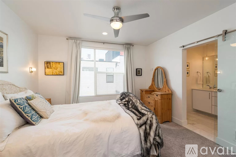 A bedroom with a large bed and a ceiling fan.