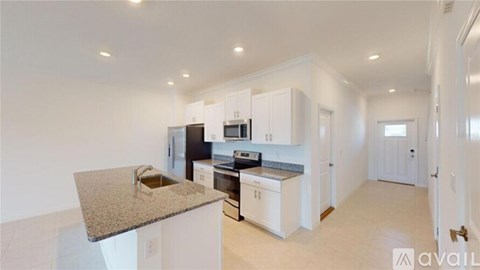 A kitchen with white cabinets and a granite countertop.