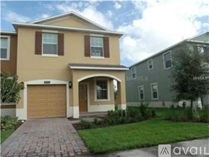 A beige house with a brown garage door is for sale.
