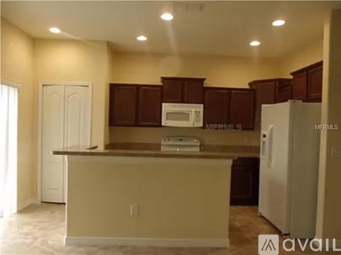A kitchen with brown cabinets and a white refrigerator.