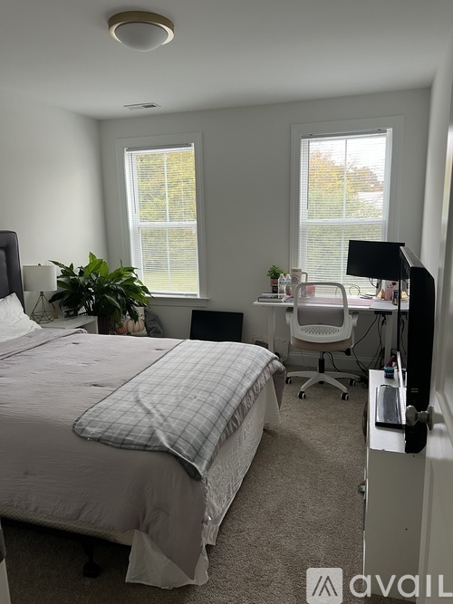A bedroom with a bed, desk, and chair.