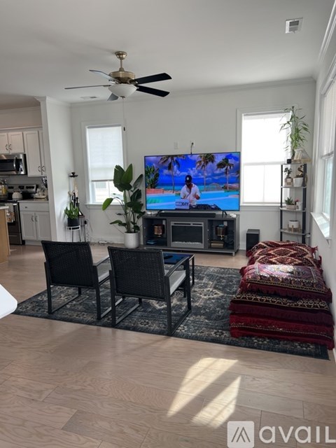 A living room with a television and a fan.