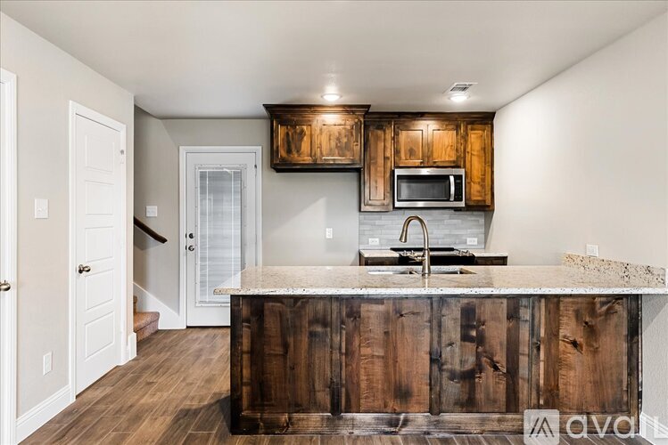 A kitchen with wooden cabinets and a marble countertop.