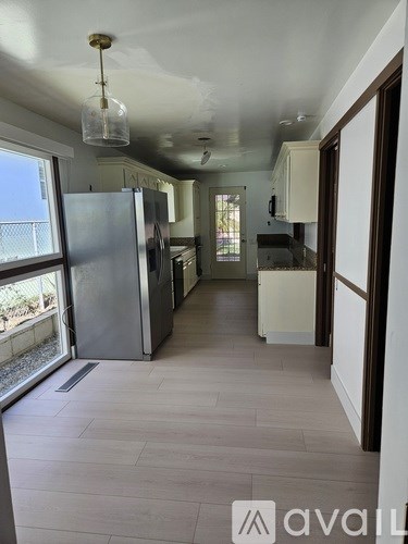 A kitchen with a refrigerator and a cabinet.