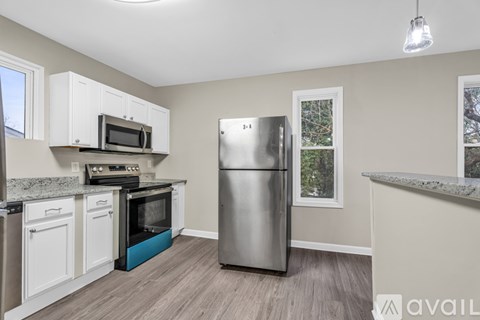 A kitchen with a stainless steel refrigerator, microwave, oven, and cabinets.