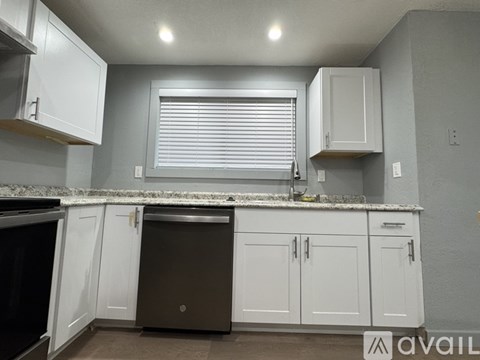 A kitchen with white cabinets and a brown dishwasher.