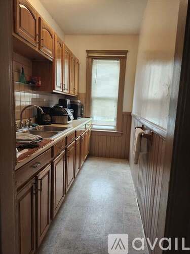 A kitchen with wooden cabinets and a window.