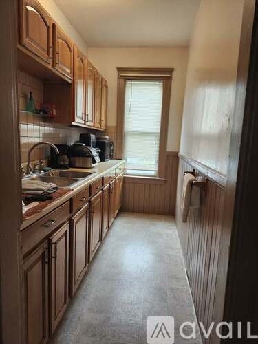 A kitchen with wooden cabinets and a window.