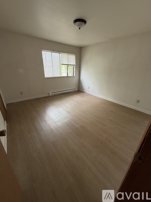 A room with wooden flooring and a window.