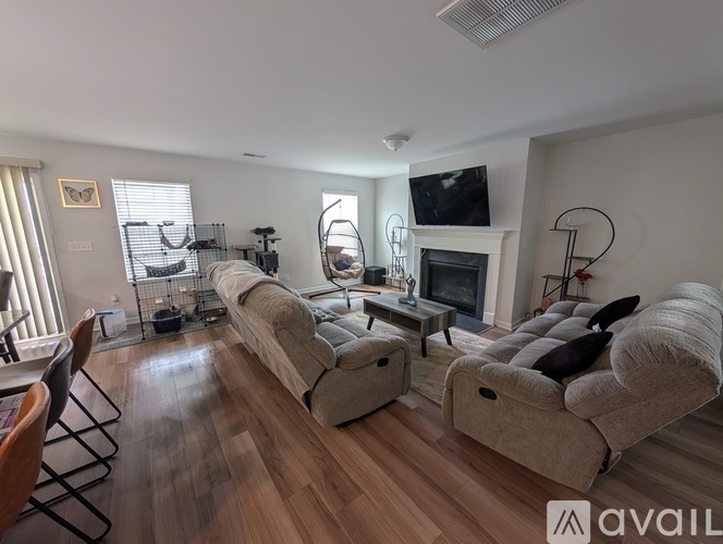 A living room with a fireplace and a television on the wall.