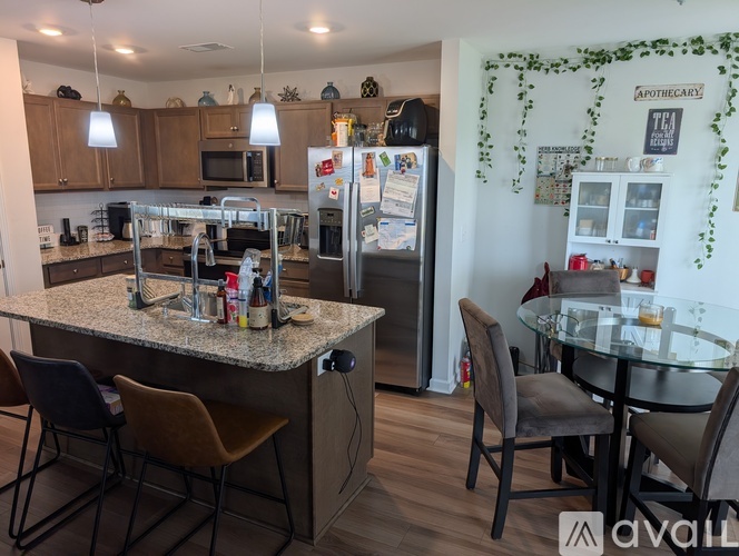 A kitchen with a granite countertop and a refrigerator with magnets on it.