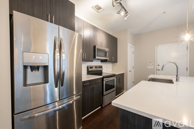A modern kitchen with stainless steel appliances and a white countertop.