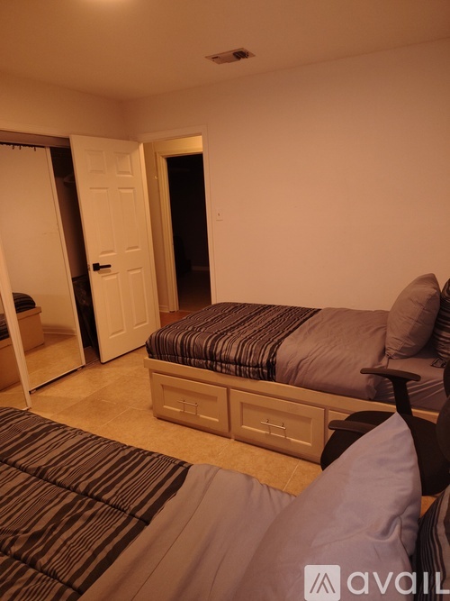 A bedroom with a bed, a dresser, and a mirror.