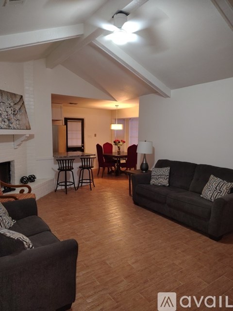 A living room with a grey couch and a fireplace.