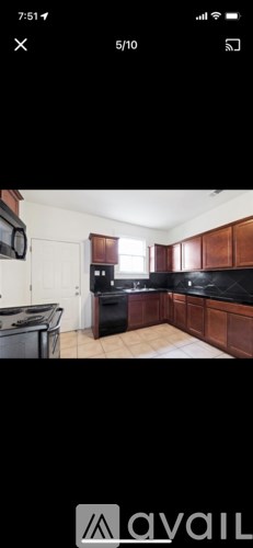 A kitchen with wooden cabinets and black countertops.