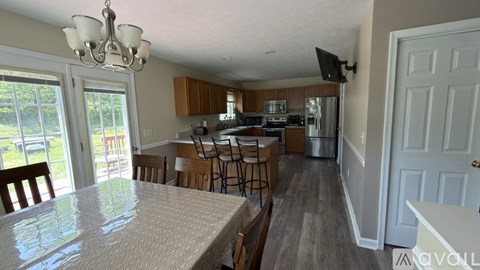 A kitchen with a table and chairs in front of a window.