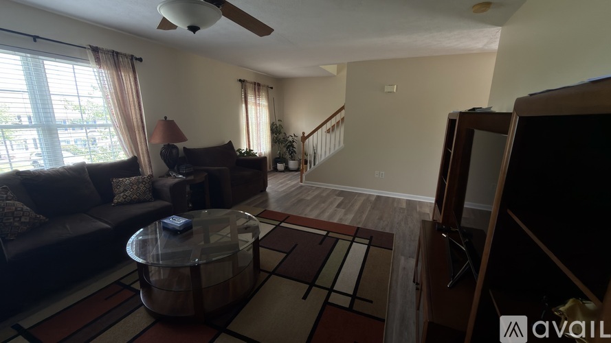 A living room with a couch, a coffee table, and a ceiling fan.