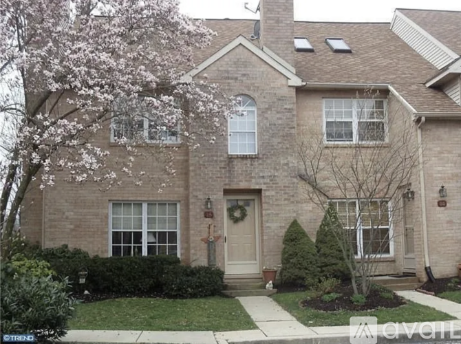 A brick house with a tree in front of it.