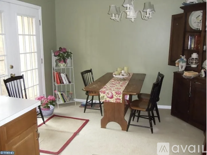 A dining room with a table set for four and a china cabinet.