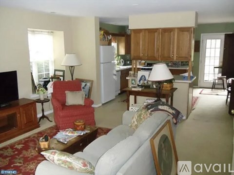 A living room with a grey couch and a red chair.