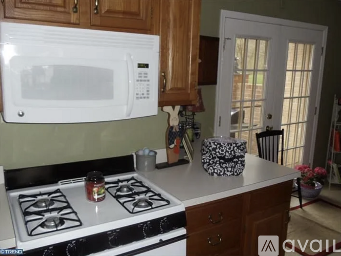 A white microwave oven is on a countertop in a kitchen.