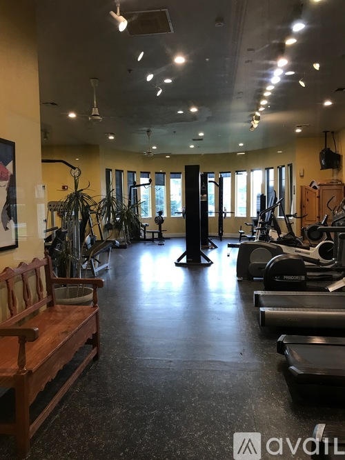 A gym with treadmills, exercise equipment, and a bench.