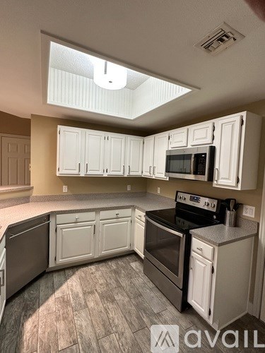 A kitchen with white cabinets and a black stove top oven.
