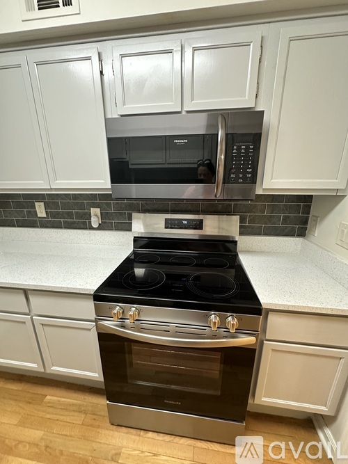 A kitchen with a stove and microwave built into the cabinetry.