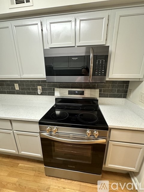A kitchen with a stove and microwave built into the cabinetry.
