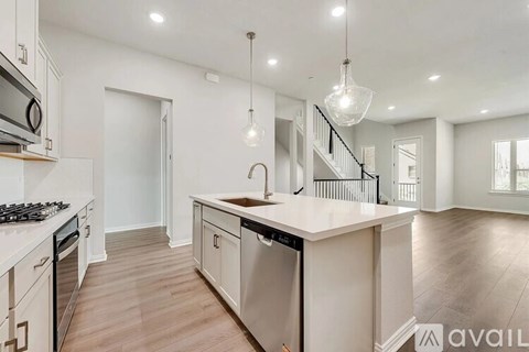 A modern kitchen with a large island and stainless steel appliances.
