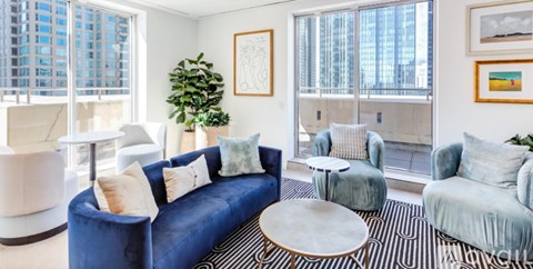 A living room with blue couches and a large window.