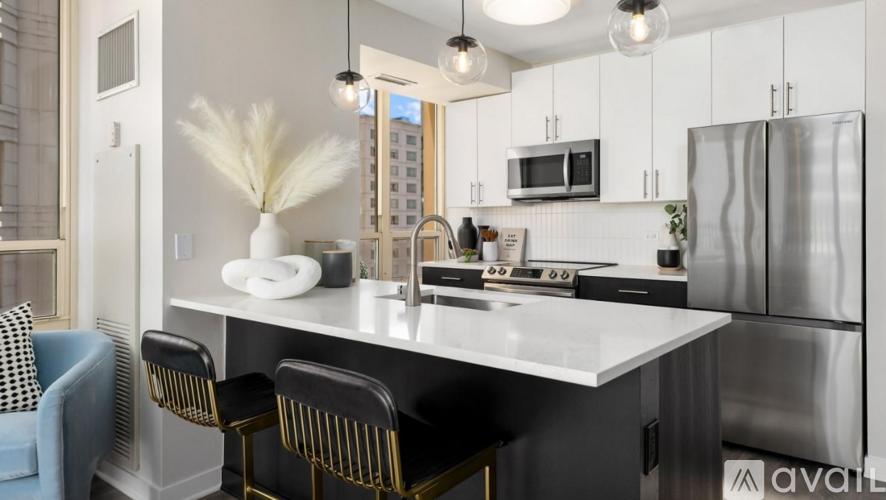 A modern kitchen with a large island and stainless steel appliances.