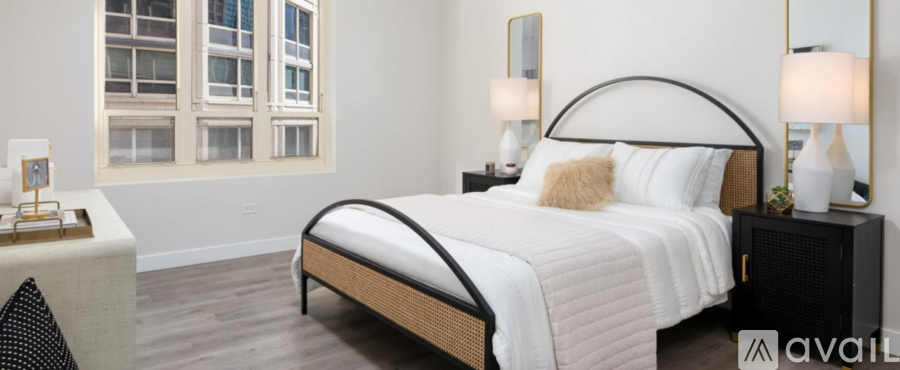 A bedroom with a large bed and a window overlooking a building.