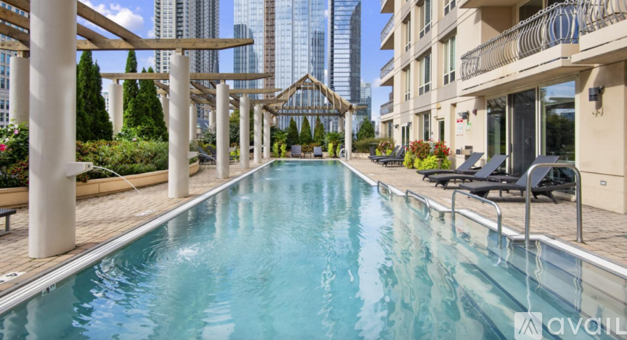 A long rectangular pool with a wooden deck and a metal railing.