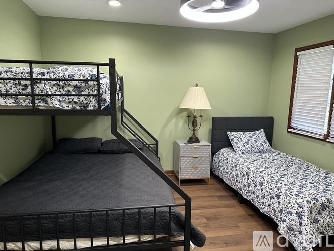 A bedroom with a bunk bed and a twin bed.
