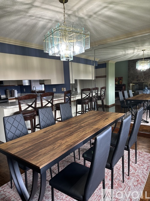 A dining room with a wooden table and chairs.