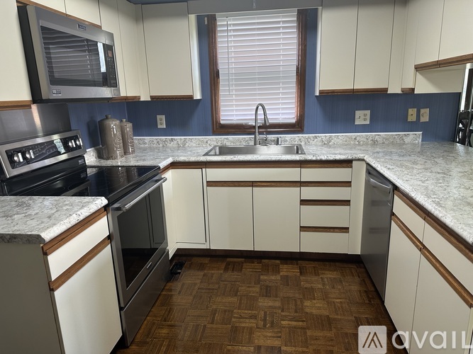 A kitchen with white cabinets and a marble countertop.