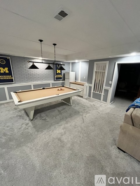 A pool table in a room with a carpeted floor.