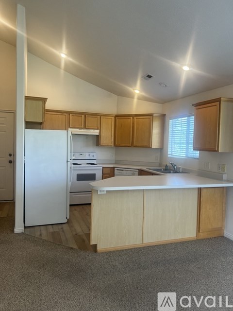 A kitchen with wooden cabinets and a white refrigerator.