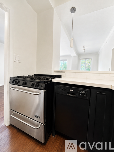 A modern kitchen with a stainless steel oven and black dishwasher.