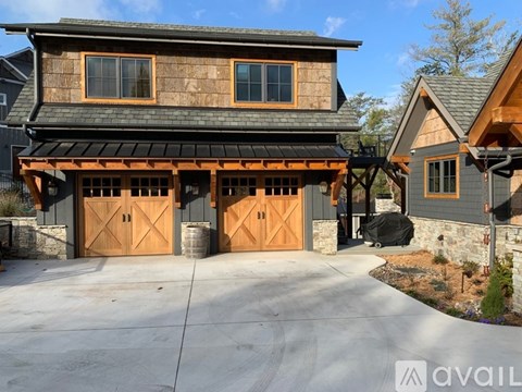 A modern house with a large garage and two doors.