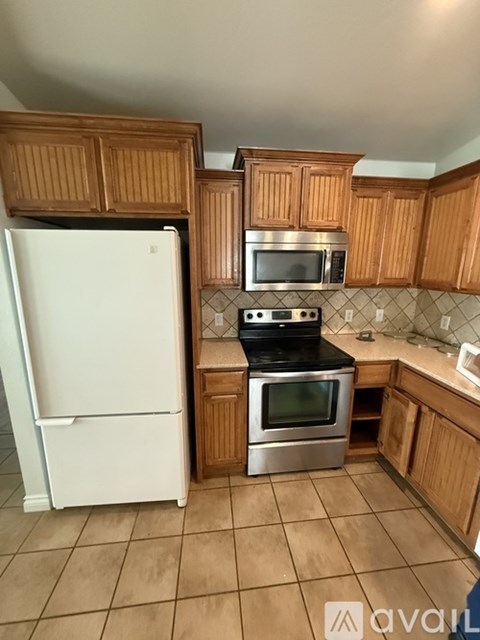 A kitchen with wooden cabinets and a white refrigerator.