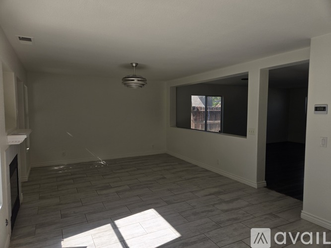 A living room with a fireplace and a large window.