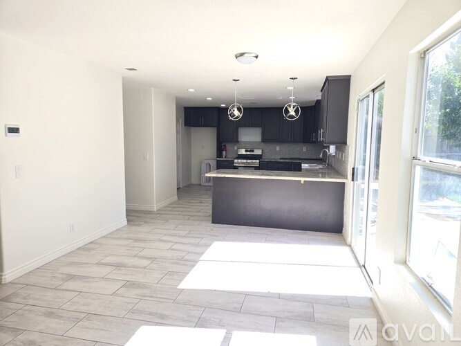 A kitchen with a black countertop and cabinets is shown.