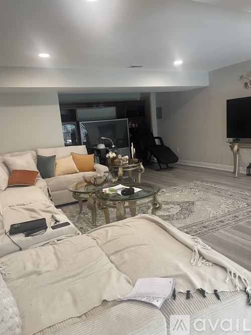 A living room with a glass coffee table and a white couch.